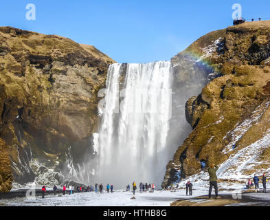 Wasserfall Skogafoss, Island, mit Regenbogen und blauer Himmel im Winter Stockfoto