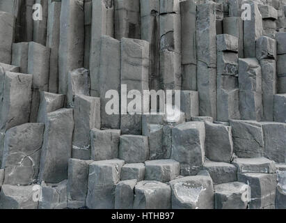 Stapel von grauen vulkanischen sechseckige Basalt vulkanischen Felsen spalten, Reynisfjara, Island Stockfoto