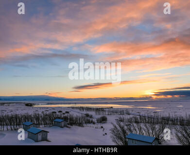 Bunte sunrise auf einer niedrigen Horizont im Winter in Island, mit bungalow Chalets im Vordergrund Stockfoto