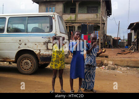 Drei Mädchen aus Nigeria posieren für ein Porträt in der Mitte der Straße, in der großen Stadt von Lagos, Nigeria Stockfoto