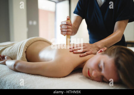 Masseur massieren weiblich auf Bett während sie entspannt Stockfoto