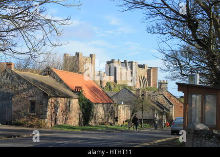 Bamburgh Castle erhebt sich über den Dächern von Bamburgh, Northumberland, England, UK Stockfoto