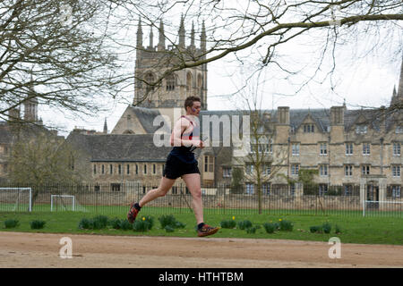 Ein männlicher Club Läufer vorbei Merton College Kapelle der Teddy Hall Schaltschütze, Oxford, UK Stockfoto