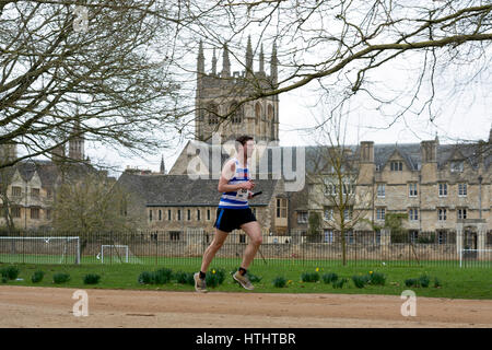 Ein männlicher Club Läufer vorbei Merton College Kapelle der Teddy Hall Schaltschütze, Oxford, UK Stockfoto