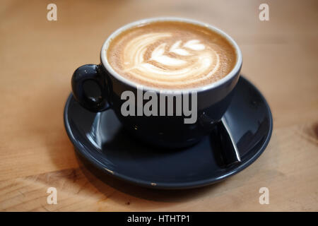 Flache weiße Kaffee in einem Restaurant, auf einem Holztisch Stockfoto
