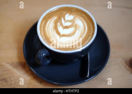 Flache weiße Kaffee in einem Restaurant, auf einem Holztisch Stockfoto