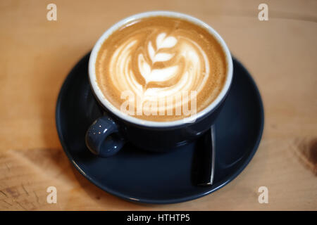 Flache weiße Kaffee in einem Restaurant, auf einem Holztisch Stockfoto