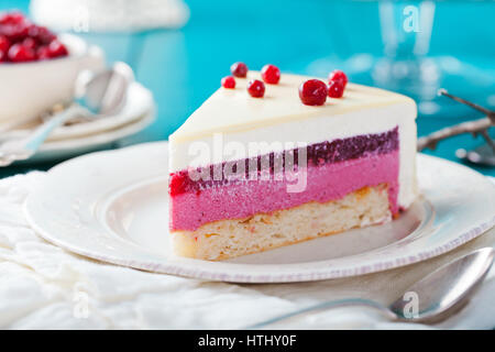 Cranberry, Heidelbeere, Himbeere Torte, Mousse Torte, Kuchen, Käsekuchen mit frischen Heidelbeeren auf blauem Untergrund aus Holz Stockfoto