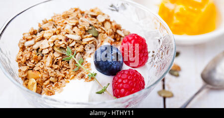 Gesundes Frühstück. Frisches Müsli, Müsli mit Milch und Beeren auf einem weißen Hintergrund in Schüssel geben. Stockfoto