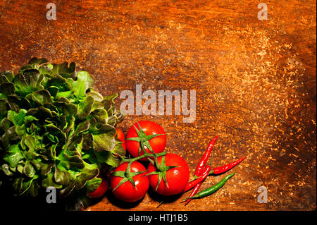 Draufsicht auf frischen Kräutern, Tomaten und Paprika auf hölzernen rustikalen Bakcground mit einem Platz für eine Inschrift. Stockfoto