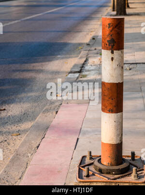 Industrielle Straße Metallstange in rote und weiße Farbe auf konkrete Fußweg verbunden dient dazu, den Raum zwischen Straße und Gehweg teilen. Stockfoto