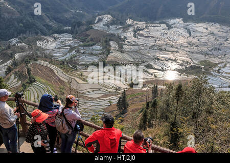 YuanYang, China - 20. Februar 2017: Menschen den Sonnenuntergang über Reisterrassen von YuanYang in Yunnan, China. YuanYang ist eines der jüngsten UNESCO-Wor Stockfoto