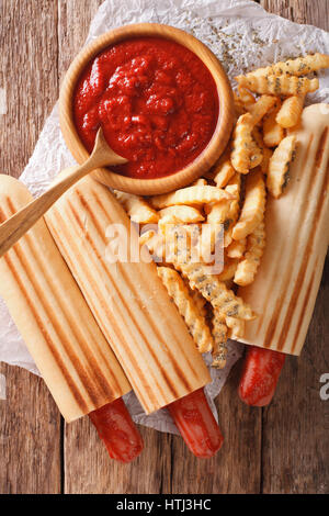 Würzige französischen Hot-Dog Brötchen mit Pommes und Ketchup Closeup auf dem Tisch. Vertikale Ansicht von oben Stockfoto