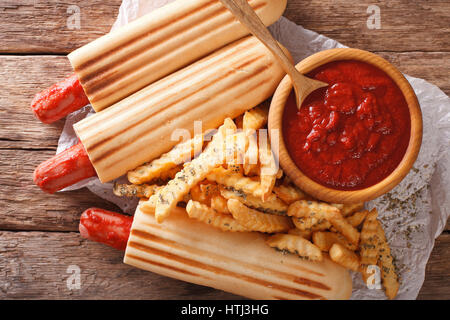 Würzige französischen Hot-Dog Brötchen mit Pommes und Ketchup Closeup auf dem Tisch. horizontale Ansicht von oben Stockfoto