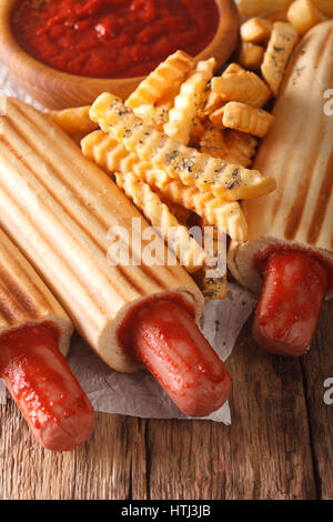 Würzige französischen Hot-Dog Brötchen mit Pommes und Ketchup Closeup auf dem Tisch. Vertikal Stockfoto