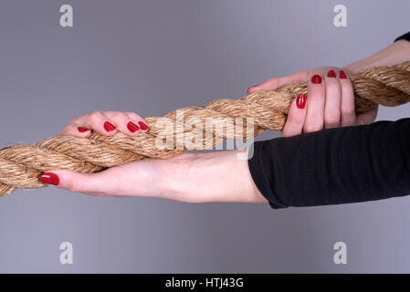 Frauenhand mit lackierten Nägeln greifen ein Seil Stockfoto
