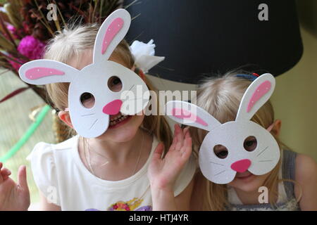 Blonde Kinder Mädchen Schwestern tragen bunny Masten zu Ostern, Ostern Spaß mit Hasen und Schokolade Stockfoto