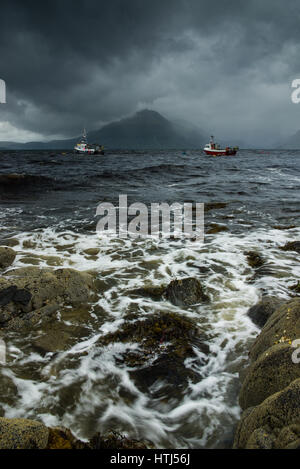 Ein Sommer Sturm vorbei über die Cuilin Berge und Fischerboote im Meer, wie von der felsigen Küste von Elgol, Isle Of Skye, Schottland gesehen Stockfoto