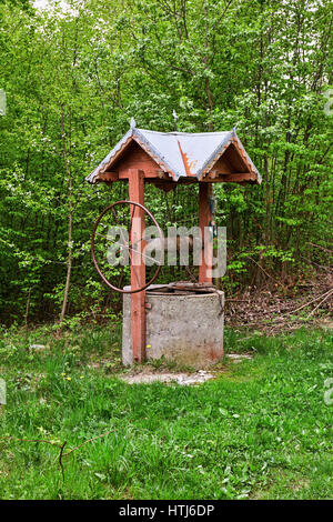 Einem alten hölzernen Brunnen im Wald. Stockfoto