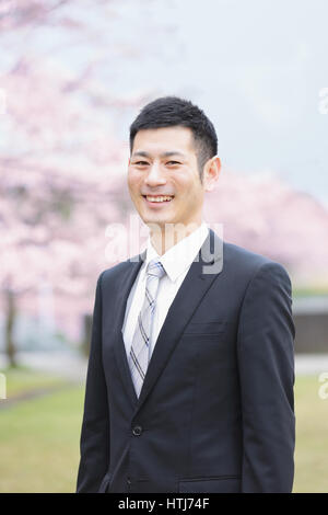 Japaner mit Kirschblüten in einem Stadtpark Stockfoto