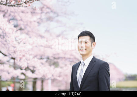 Japaner mit Kirschblüten in einem Stadtpark Stockfoto