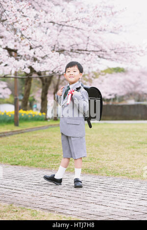 Japanische Kinder mit Kirschblüten in einem Stadtpark Stockfoto