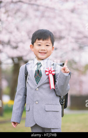 Japanische Kinder mit Kirschblüten in einem Stadtpark Stockfoto