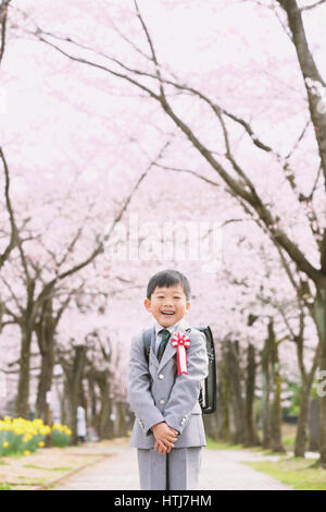 Japanische Kinder mit Kirschblüten in einem Stadtpark Stockfoto