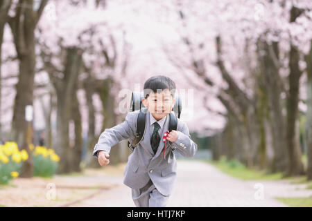 Japanische Kinder mit Kirschblüten in einem Stadtpark Stockfoto