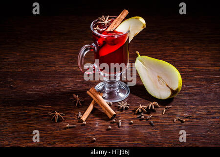 Birne Glühwein Apfelwein mit Vanille, Zitronenscheibe und Zimtstangen auf einem hölzernen Hintergrund Stockfoto