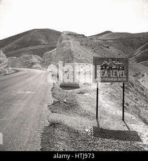 1950er-Jahren, historische Bild zeigt zwei Meeresspiegel Zeichen neben einer Bergstraße, Jordanien. Stockfoto