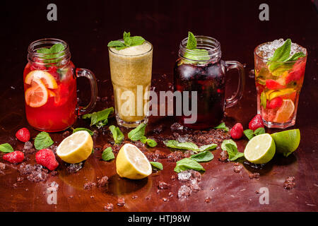 Cocktails im Glas mit rohem Obst auf Holztisch mit crashed ice Stockfoto