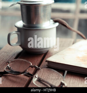 Kaffeezeit morgens entspannen Moment in der regnerischen Tag, Kaffeetasse im Café-Tisch mit Fenster Hintergrund, langsam Leben mit Genuss Stockfoto