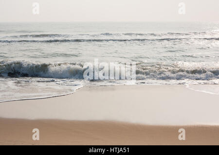 Glitzernde Meereswellen an einem tropischen Strand am Morgen. Stockfoto