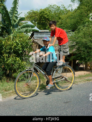 DONG THAP, VIET NAM - Sept. 23, 2014: Zwei nicht identifizierte asiatischen Kind Fahrt Fahrrad auf Landstraße in Gefahr Situation, vietnamesische Kinder Radfahren sehr dang Stockfoto