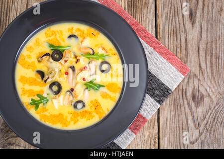 Gemüsesuppe-Püree mit Muscheln in schwarze Platte auf hölzernen Hintergrund. Studio Photo Stockfoto