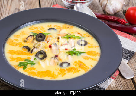 Gemüsesuppe-Püree mit Muscheln in schwarze Platte auf hölzernen Hintergrund. Studio Photo Stockfoto