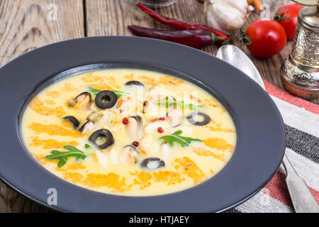 Gemüsesuppe-Püree mit Muscheln in schwarze Platte auf hölzernen Hintergrund. Studio Photo Stockfoto