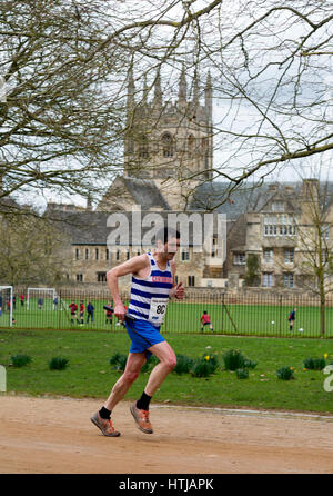 Ein männlicher Club Läufer vorbei Merton College Kapelle der Teddy Hall Schaltschütze, Oxford, UK Stockfoto