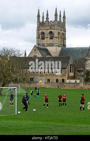 Merton College Kapelle mit Schulkindern üben Fußball im Vordergrund, Oxford, UK Stockfoto