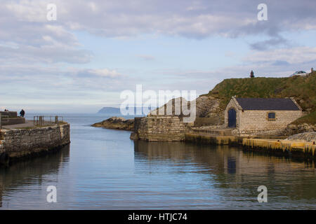 Der kleine Hafen von Ballintoy auf der North Antrim Küste Nordirlands mit seinen Stein gebaut Bootshaus im Meer reflektieren Stockfoto