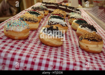 Sortierte Vereisung Donuts auf karierte Tischdecke Stockfoto