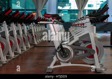 Fitness-Training im Fitness-Studio: Gruppe von modernen Spinning Bikes in Zeile Stockfoto