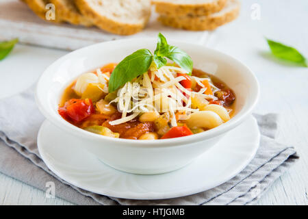 Hausgemachte italienische Minestrone-Suppe mit Käse und Basilikum - gesunde hausgemachte heiße vegetarische Ernährung vegane Mahlzeit essen Suppe Stockfoto