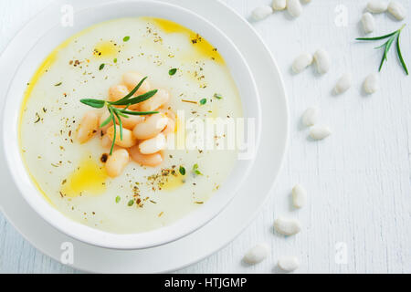 Cremige weiße Bohnen und Gemüsesuppe mit Rosmarin in weiße Schüssel - gesunde hausgemachte vegetarische vegane Suppe essen Diätkost Stockfoto