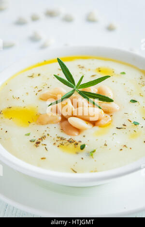 Cremige weiße Bohnen und Gemüsesuppe mit Rosmarin in weiße Schüssel - gesunde hausgemachte vegetarische vegane Suppe essen Diätkost Stockfoto