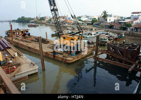 HO CHI MINH CITY, VIET NAM, Group of Asia Arbeiter arbeiten auf der Baustelle, vietnamesische Mann bauen Brücke über Wasser, sie am Stahlgerüst arbeiten Stockfoto