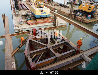 HO CHI MINH CITY, VIET NAM, Group of Asia Arbeiter arbeiten auf der Baustelle, vietnamesische Mann bauen Brücke über Wasser, sie am Stahlgerüst arbeiten Stockfoto