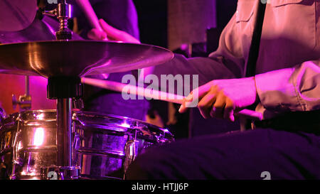 Schlagzeuger spielt Schlagzeug und Becken mit Drumsticks auf der Bühne. Jazz oder Rock Konzert Leistung Unterhaltung. Schuss mit weichen selektive f hautnah Stockfoto