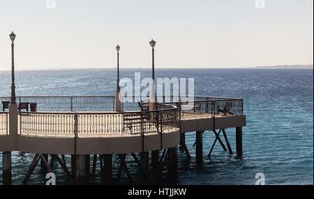 Stein-Pier auf Pfählen mit Bänken, Laternen und geschmiedete Zäune. Stockfoto